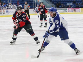 David Levin, right, of the Sudbury Wolves, prepares to pass the puck to a teammate as Aaron Luchuk, of the Windsor Spitfires, attempts to poke the puck away during OHL action at the Sudbury Community Arena in Sudbury, Ont. on Friday October 23, 2015. John Lappa/Sudbury Star/Postmedia Network