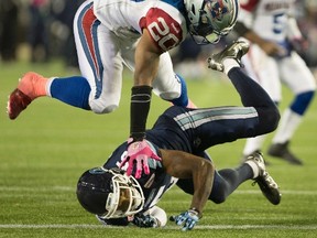 Alouettes running back Tyrell Sutton goes over Argonauts safety Jermaine Gabriel for a touchdown on Friday night in Hamilton. (THE CANADIAN PRESS/PHOTO)