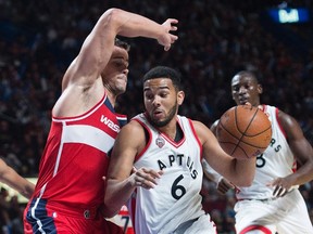 Toronto Raptors' Cory Joseph, right, drives to the basket as Washington Wizards' Kris Humphries defends during first quarter pre-season basketball action in Montreal on Oct. 23, 2015. (THE CANADIAN PRESS/Graham Hughes)