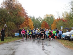 Liz Wismer-Van Meer (far left) blows the air horn to mark the start of the 10K Cool Runnings Trail Race on Oct. 24. More than 150 participants ran among the colourful fall leaves in two races to raise money for the Canadian Cancer Society. (MEGAN STACEY/Sentinel-Review)