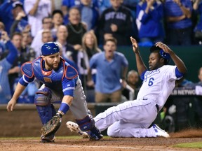 Toronto Blue Jays catcher Russell Martin, left, fields the throw to the plate as Kansas City Royals' Lorenzo Cain scores during eighth inning game six American League Championship Series baseball action in Kansas City, Mo., on Friday, October 23, 2015. (THE CANADIAN PRESS/Nathan Denette)