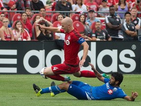 Toronto FC midfielder Michael Bradley is taken down by Montreal defender Victor Cabrera during a game earlier this season. (USA TODAY SPORTS)