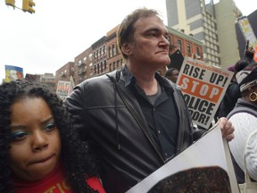 Director Quentin Tarantino, centre, participates in a rally to protest against police brutality Saturday, Oct. 24, 2015, in New York. Speakers at the protest said they want to bring justice for those who were killed by police. (AP Photo/Patrick Sison)