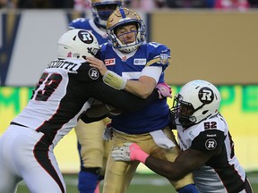 Winnipeg Blue Bombers QB Matt Nichols is sacked by Ottawa RedBlacks DL Justin Capicciotti (left) and DL Shawn Lemon during CFL action in Winnipeg on Sat., Oct. 24, 2015. Kevin King/Winnipeg Sun/Postmedia Network