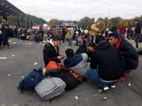 Refugees rest at the Slovenian-Austrian border in Spielfeld, Austria, Friday, Oct. 23, 2015. Thousands of people are trying to reach central and northern Europe via the Balkans but often have to wait for days in mud and rain at the Serbian, Croatian and Slovenian border. (Akos Treba/MTI via AP)