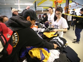 Volunteers Lynn Ly (r) and Sarah Bellerose (c) works at a pop up clothing store for the homeless at the Boyle Street Community Hall in Edmonton, Alberta on October 24, 2015. Perry Mah/Edmonton Sun/Postmedia Network
