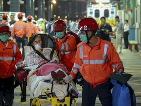 An injured ferry passenger is escorted by rescuers after getting onshore in Hong Kong, China October 25, 2015.  About 100 people were injured on Sunday when a ferry returning from Macau to Hong Kong collided with an unknown object, a police department official said.  REUTERS/Stringer