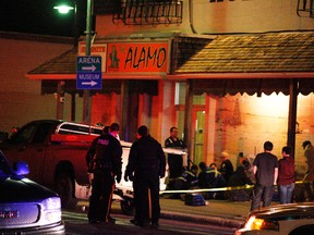 Mounties congregate near where other first responders attend to a person on Sunday October 25, 2015 outside the Alamo bar in Sexsmith, Alta. At least two people were taken away in an ambulance and a third was transported by STARS Air Ambulance. The scene was marked off with crime scene tape by the RCMP, who haven't yet released details about the incident. Tom Bateman/Grande Prairie Daily Herald-Tribune/Postmedia Network