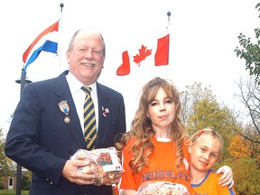 Dresden Legion president Brian McCabe, along with Brenda and Emma Goodreau, show offsome of the 700 tulip bulbs that were planted on Saturday, October 24, 2015 at Dresden Legion Branch 113 in Dresden, Ontario. The local legion is among the 140 recipients of 70th Anniversary Dutch - Canadian Friendship Tulip Gardens being planted across Canada. (DAVID GOUGH/COURIER PRESS/Postmedia Network)