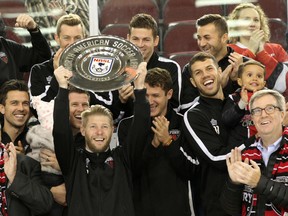 Ottawa Fury FC captain Richie Ryan hoists  the NASL fall championship trophy as teammates and coaches cheer during a ceremony at TD Place before the Ottawa 67's game on Sunday, Oct. 25, 2015. (Chris Hofley/Ottawa Sun)