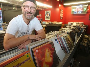 Lawyer Darren Sawchuk leans on a rack of albums in his store Vinyl Revival in Winnipeg Oct. 25, 2015. (Brian Donogh/Winnipeg Sun/Postmedia Network)
