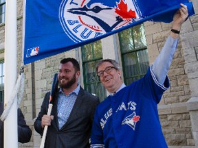 Ottawa Mayor Jim Watson (R), along with city councillor and Sports Commissioner Jody Mitic, raised the Toronto Blue Jays flag at City Hall on Thursday October 8, 2015. Errol McGihon/Ottawa Sun