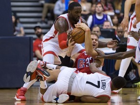 Toronto Raptors' Patrick Patterson and Kyle Lowry vie for a loose ball against Los Angeles Clippers' Blake Griffin during the second half of a pre-season game in Vancouver on Oct. 4, 2015. (THE CANADIAN PRESS/Darryl Dyck)