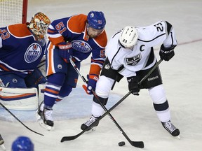 Edmonton Oilers' Anton Lander  fights for the puck with  LA Kings captain  Dustin Brown during second period NHL action at Rexall Place in Edmonton, Alberta on October 25, 2015. Perry Mah/Edmonton Sun/Postmedia Network