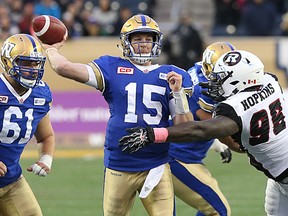 Winnipeg Blue Bombers QB Matt Nichols is hit by Ottawa RedBlacks DL Moton Hopkins as he releases a Hail Mary attempt on the final play of CFL action in Winnipeg on Sat., Oct. 24, 2015. Kevin King/Winnipeg Sun/Postmedia Network