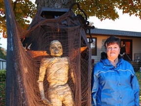 Carol McLachlan stands next to a mummy at her haunted house in Egmondville. She has been renting out Halloween costumes and decorating her front yard for decades.(Shaun Gregory/Huron Expositor)
