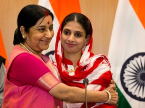 India's External Affairs Minister Sushma Swaraj, left, hugs Geeta, 23, a deaf and mute Indian woman who accidentally strayed into Pakistan as a child, during a press conference in New Delhi, India, on Oct. 26, 2015. (AP Photo/Manish Swarup)