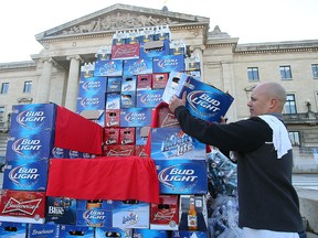 Angelo Mondragon, owner of the Notre Dame Hotel, stacked beer cases outside the Manitoba Legislative Building on Monday. Mondragon says rural hotels receive too low of a share of VLT and vendor revenues. (Brian Donogh/Winnipeg Sun)