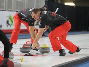 Matt Wozniak, left, and Denni Neufeld from Mike McEwen's rink sweep a rock during the Syncrude Elite 10 final in Fort McMurray, Alta., in March. Wozniak is using a broom with a controversial multi-directional brush head.
(Postmedia Network)