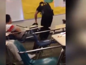 A South Carolina police officer rips a female student from desk after confrontation. (YouTube)