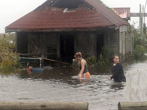 Kaitlyn Serigny and her sister Kelsie Serigny walk through floodwaters Monday, Oct. 26, 2015, in Golden Meadow, La. Rainfall of 7 inches or more put parts of Louisiana and Missisippi under flash flood watches, with coastal flood warnings as the remnants of Hurricane Patricia passed through the states and head towards Canada. (Abby Tabor/The Houma Daily Courier via AP)