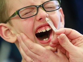 Jared Erickson, 6, reacts as he receives a nasal flu spray delivered by a an Alberta Health Services Registered Nurse at an Alberta Health Services Clinic at Brentwood Village Mall in northwest Calgary, Alta on Thursday Jan. 2, 2014. Jim Wells/Calgary Sun files