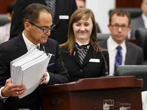 Finance Minister Joe Ceci hands out Budget 2015 documents to a legislature page before his speech on the floor of the Alberta Legislature in Edmonton, Alta., on Tuesday October 27, 2015. Ian Kucerak/Edmonton Sun/Postmedia Network