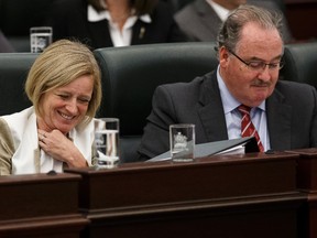 Premier Rachel Notley (left) and Minister of Infrastructure, Minister of Transportation, and Government House Leader Brian Mason listen during delivery of Budget 2015 on the floor of the Alberta Legislature in Edmonton, Alta., on Tuesday October 27, 2015. Ian Kucerak/Edmonton Sun/Postmedia Network