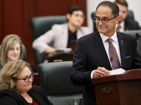 Finance Minister Joe Ceci (right) gives the Budget 2015 speech while Minister of Health and Minister of Seniors Sarah Hoffman listens on the floor of the Alberta Legislature in Edmonton, Alta., on Tuesday October 27, 2015. Ian Kucerak/Edmonton Sun/Postmedia Network