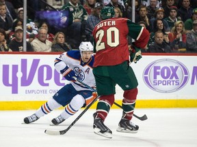 Taylor Hall tries to move the puck past Wild defenceman Ryan Suter during the first period of Tuesday's game in St. Paul, Minn. (USA TODAY SPORTS)