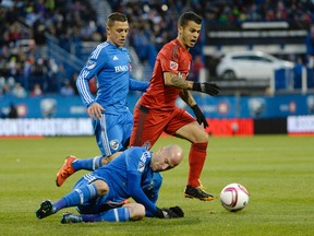 Toronto FC forward Sebastian Giovinco avoids the tackle of Montreal Impact defender Laurent Ciman during the first half at Stade Saputo on Oct. 25, 2015. (Eric Bolte/USA TODAY Sports)