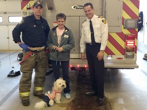 Photo supplied
Lee Duguid, with pet Teddy, is flanked by firefighter Barry Moore, left, and Jesse Oshell, assistant deputy fire chief. Duguid was instrumental in sourcing a donation of 10 oxygen masks that are suitable for animals.