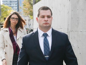 Toronto Police Const. James Forcillo leaves 361 University Ave. courts with his wife on Oct. 13, 2015. (STAN BEHAL/Toronto Sun)