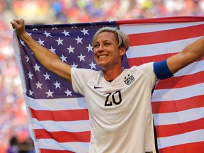 In this July 5, 2015, file photo, United States’ Abby Wambach holds an American flag after the U.S. beat Japan 5-2 in the Women’s World Cup championship game in Vancouver. (AP Photo/Elaine Thompson, File)