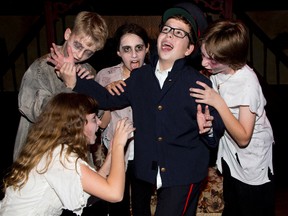 Maddy Leushner, Ben Dixon, Mica Mellicovsky, and Liam Derbyshire snack on Nathan Martin in a scene from the Original Kids Theatre Company's production of Teenage Night of Horror. (DEREK RUTTAN, The London Free Press)