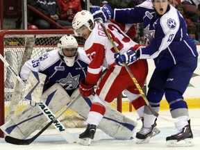 Sudbury Wolves netminder Zack Bowman keeps an eye on the puck through Soo Greyhounds' Gabe Guertler and Wolves centre Michael Pezzetta during OHL action at Essar Centre in Sault Ste. Marie on Wednesday night.