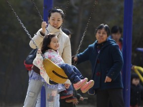 A mother pushes her daughter on a swing in Beijing in this April 3, 2013 file photo. China will ease family planning restrictions to allow all couples to have two children after decades of the strict one-child policy, the ruling Communist Party said on October 29, 2015, a move aimed at alleviating demographic restraints on the economy. (REUTERS/Jason Lee/Files)