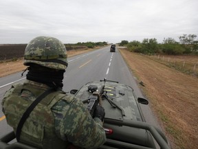 A soldier stands guard atop a military vehicle while patrolling the outskirts of the town of San Fernando, in the Mexican state of Tamaulipas. (REUTERS/Tomas Bravo)