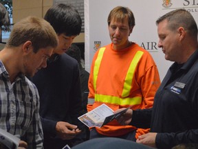 Jeff Gallie, right, talks to William Bloom and Jay Lee about working for Union Gas. Bloom and Lee are electrical engineering students from St. Clair College, where Union Gas was looking to stir up interest in company opportunities Thursday. Photo taken on Thursday, Oct. 29. Louis Pin // Chatham This Week.