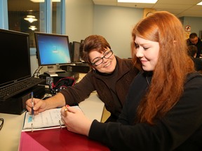 Resource teacher Lorraine Savignac works with Jamie MacDonald, 16, in the resource centre at  Ecole secondaire du Sacre-Coeur in Sudbury, Ont. on Thursday October 29, 2015. Savignac will be presented with the 2015 Ontario Federation for Cerebral Palsy Outstanding Teacher Award at a ceremony in Toronto on Friday, October 30, 2015. John Lappa/Sudbury Star/Postmedia Network