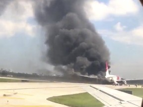 A still image from a handout video footage by Mike Dupuy, a passenger in another airplane, shows Dynamic International Airways' Boeing 767's engine on fire in Fort Lauderdale, Florida October 29, 2015. Passengers were forced to evacuate the Dynamic International Airways' Boeing 767 headed for Venezuela on Thursday after the plane's engine caught fire on the airport runway in Fort Lauderdale, Florida, officials said. REUTERS/Mike Dupuy/Handout via Reuters