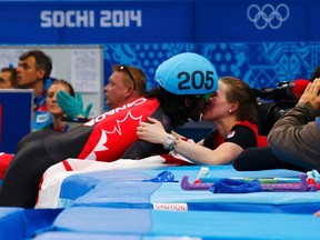 Charles Hamelin kisses his girlfriend and compatriot speedskater Marianne St. Gelais after winning the men's 1,500-metre short track race during the 2014 Sochi Olympics on Feb. 10, 2014. (David Gray/Reuters/Files)
