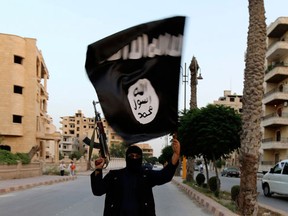 A member loyal to ISIS  waves a flag in Raqqa. (REUTERS/Stringer)