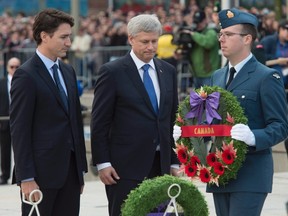 A member of the Canadian Forces presents Prime Minister Stephen Harper and prime minister-designate Justin Trudeau with a wreath to place during a ceremony marking the one year anniversary of the attack on Parliament hill Thursday Oct. 22, 2015 at the National War Memorial in Ottawa. THE CANADIAN PRESS/Adrian Wyld