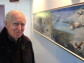 Aviation artist Don Connolly stands next to the mural he painted to showcase Kingston's aviation history in the control tower at Norman Rogers airport in Kingston on Tuesday. (Michael Lea/The Whig-Standard)
