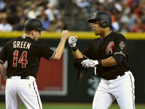 Yasmany Tomas (right) of the Arizona Diamondbacks celebrates with third base coach Andy Green after driving in two runs against the Chicago Cubs at Chase Field on May 23, 2015 in Phoenix. (Norm Hall/Getty Images/AFP)