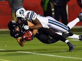 Ottawa Redblacks receiver Brad Sinopoli gets tackled by Toronto Argonauts defender Brandon Isaac during CFL action in Ottawa on Tuesday, Oct 6, 2015. (THE CANADIAN PRESS/Sean Kilpatrick)