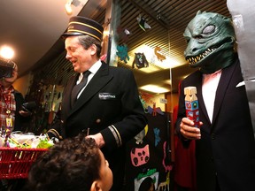 Mayor John Tory, dressed as a conductor for his proposed SmartTrack transit plan, and Deputy Mayor Denzil Minnan-Wong, dressed as Gorn from Star Trek, hand  out candies to kids from the City Hall daycare on Friday, Oct, 30, 2015. (MICHAEL PEAKE/Toronto Sun)