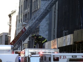 A New York City firefighter works on the scene where a building undergoing demolition work partially collapsed, in New York October 30, 2015. The building partially collapsed on Friday, killing one person and trapping another in the rubble, authorities said. Approximately 65 firefighters responded to the collapse, which occurred about 10:30 a.m. in the rear of a multistory building on West 38th Street in midtown Manhattan, a fire department spokesman said. (REUTERS/Brendan McDermid)