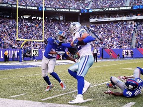 Cowboys tight end Jason Witten (centre) catches the ball under pressure from Giants defenders Brandon Meriweather (22) and Jayron Hosley (28) during second quarter NFL action at MetLife Stadium in East Rutherford, N.J., on Sunday, Oct. 25, 2015. (Elsa/Getty Images/AFP)